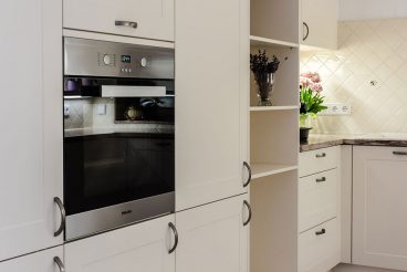 Raumhohe Schränke, ausgestattet mit ergonomisch angeordneten Einbauelementen wie Backofen Miele H2261-1BED und verstecktem Kühlschrank