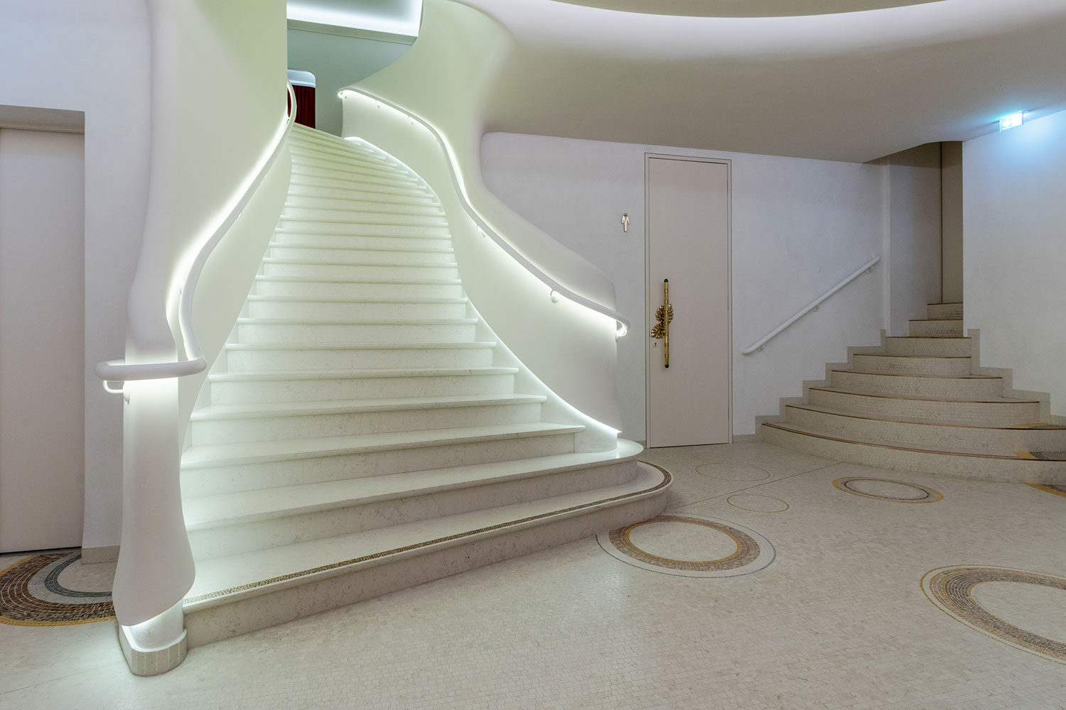 Design: Bennett + Böhme Vision, Foto: Alexander Kroeker - Mit Mosaik besetzte, einläufge, geschwungene helle Marmortreppe